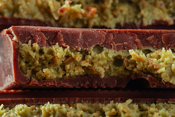 Close-up of Dubai chocolate pieces with a visible pistachio filling. The image highlights the smooth chocolate shell and creamy green pistachio center