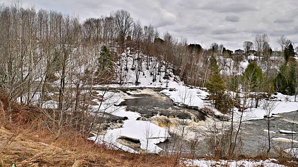 istock Shawinigan river in early spring with cataract, ice melting and trees in foreground 2239961972