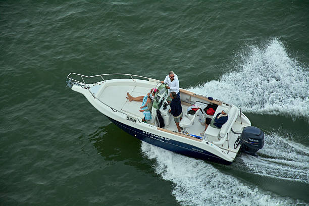Family enjoying Garda Lake vacations. Father and kids riding a boat on Lake Garda.\nNikon D850