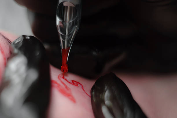Tattoo machine close up is making paint. Red ink color needle. Extreme macro