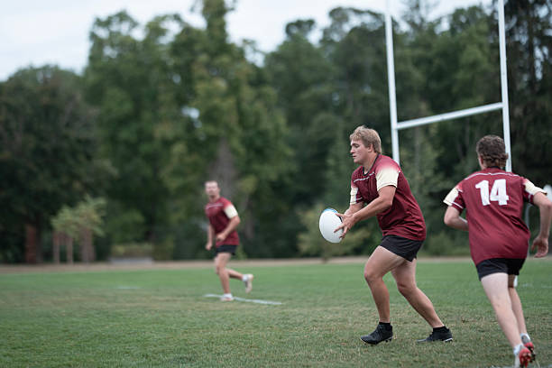 istock Rugby Players in Maroon Jerseys Pass The Ball During a Field Practice Match 2239964270