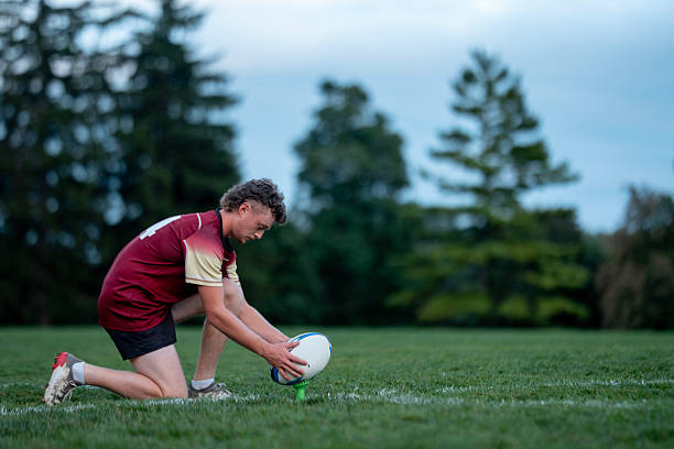 istock Caucasian Rugby Player Kneeling With Ball On Grass Field During Outdoor Training Session 2239964347