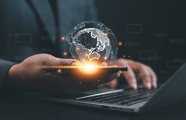 istock Businessman using smartphone and laptop with glowing digital globe hologram, representing global network connection, data innovation, technology communication, transformation for modern business. 2239964489