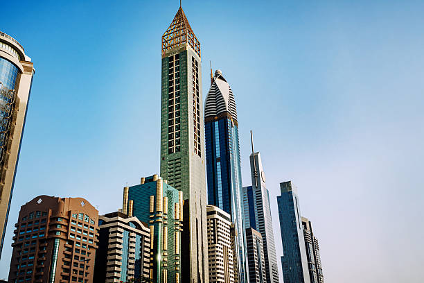 Vibrant Dubai cityscape along Sheikh Zayed Road featuring iconic high-rise towers and futuristic architecture under a bright blue sky. Ideal for architecture, business, urban development, and travel imagery.