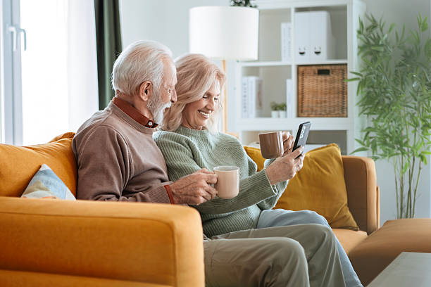 istock Senior Couple Spending Time Together at Home Using Phone 2239969602