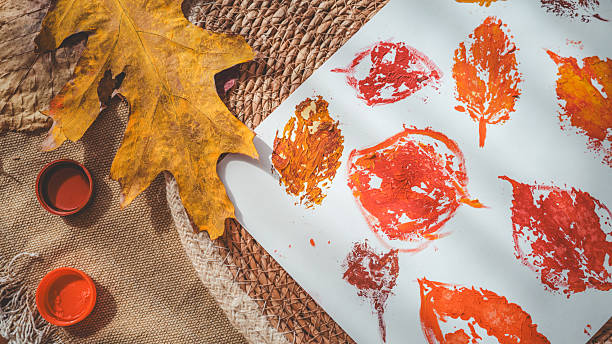 istock Autumn leaf prints on paper with paint and a large leaf 2239971526