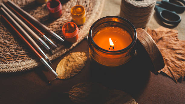istock Cozy autumn still life with a lit candle, paintbrushes, and fall leaves. 2239971538