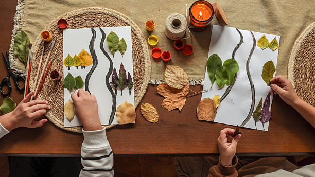 istock Kids crafting with leaves and paint 2239971553