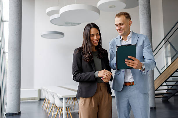 istock Business colleagues collaborating on digital tablet in modern office, discussing project strategy with smiles 2239971727