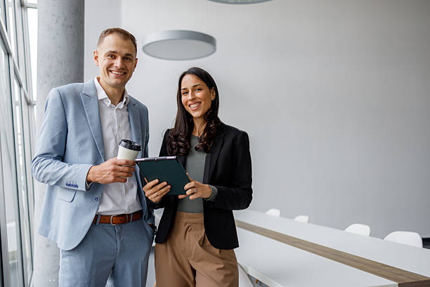 istock Professional business colleagues standing smiling in a modern office, ready for a corporate meeting or presentation 2239971938