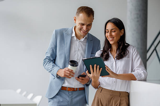 istock Business colleagues collaborating on a digital tablet during a coffee break, sharing ideas and smiling in a modern office 2239972349