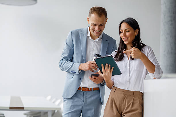 istock People smiling, analyzing data on a tablet device, working together on a project in a corporate environment 2239972410