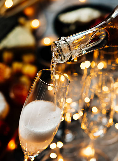 einschenken von sekt oder champagner, der für die weihnachts- oder silvesterfeier auf dem tisch serviert wird. - schaumwein stock-fotos und bilder