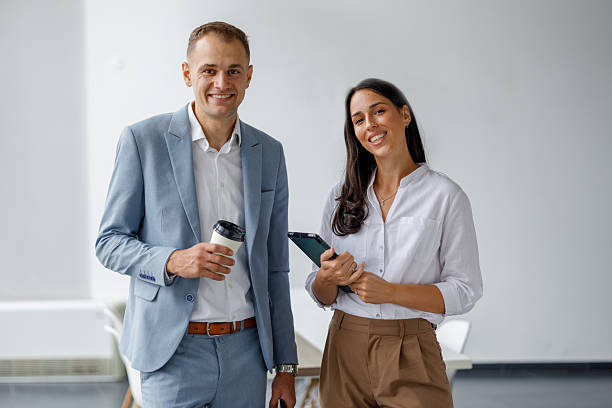 istock Business partners smiling, collaborating, and discussing ideas in a modern office during a coffee break 2239972577