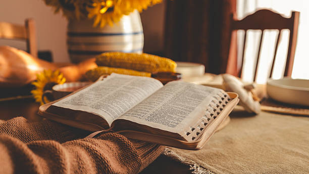 istock Thanksgiving table setting with an open Bible and autumn decorations. 2239972873