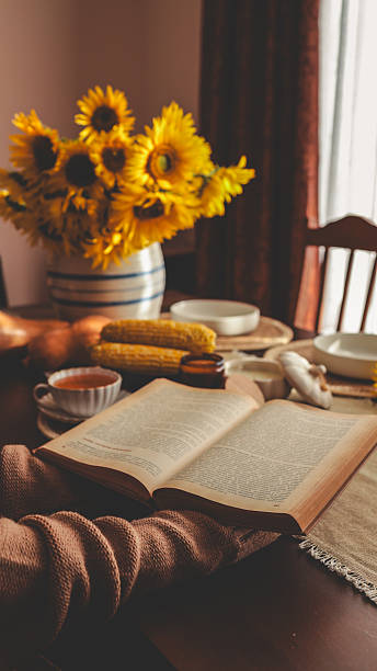 istock Cozy autumn scene with sunflowers, book, and warm tea on a table. 2239972874