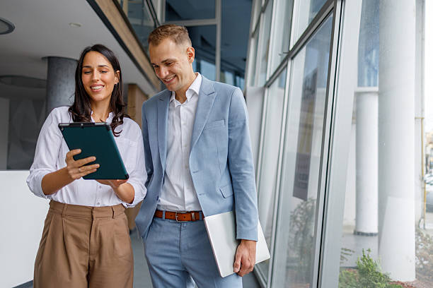 istock Business colleagues collaborating on digital tablet, discussing project ideas in modern office building 2239973727