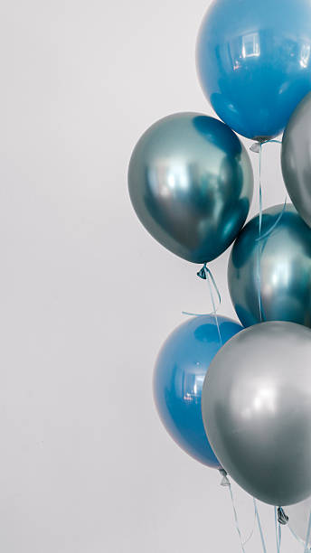 istock A cluster of blue and silver balloons against a plain white background. 2239974665