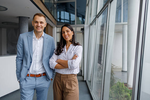 istock Business colleagues standing by a large window in a modern office, smiling, confident and ready for new challenges 2239974820