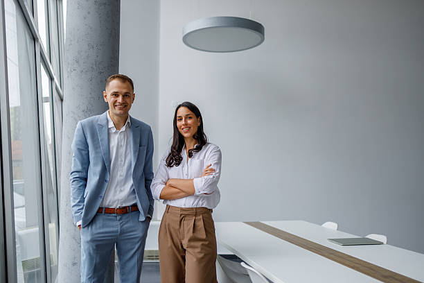 istock Business colleagues smiling while standing in modern office, portraying teamwork and success 2239974968