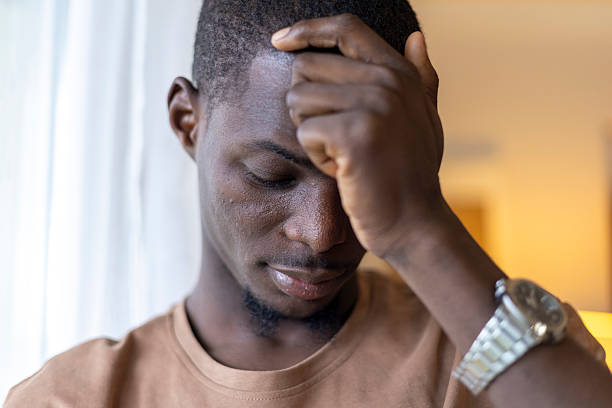 istock Black man experiencing stress and headache, covering his face with hand 2239976153