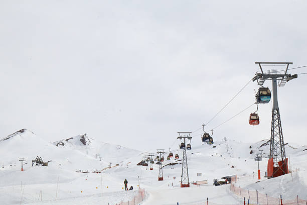 istock Colorful Ski Gondolas Moving Above Snowy Mountains on a Winter Day 2239976325