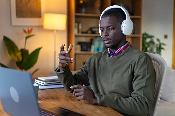 istock Young man using laptop for video call, working remotely from home 2239976397