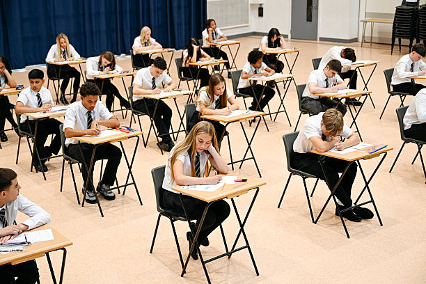 istock Secondary school children sitting exam in hall with desks spaced out, concentration, opportunity, focus 2239976414