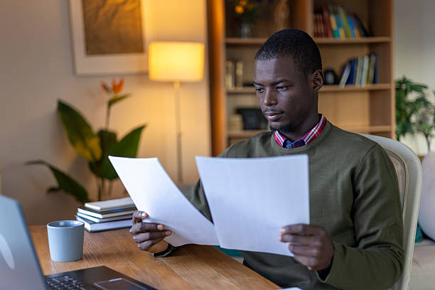 istock Young man concentrating on documents, working from home at desk 2239977081