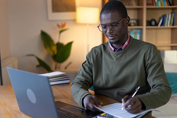 istock African american man writing documents at home office with laptop, studying remotely 2239977121