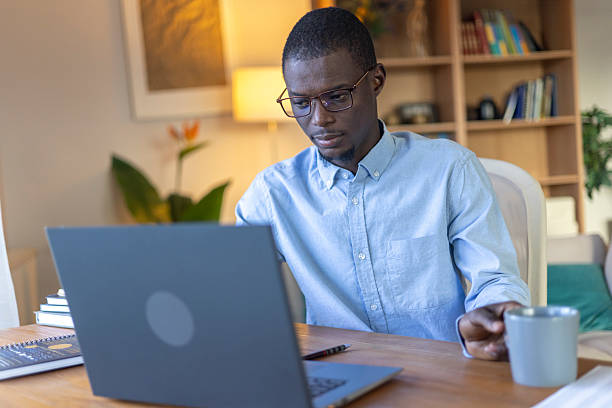 istock Young black man working from home using laptop, remote online education 2239977173