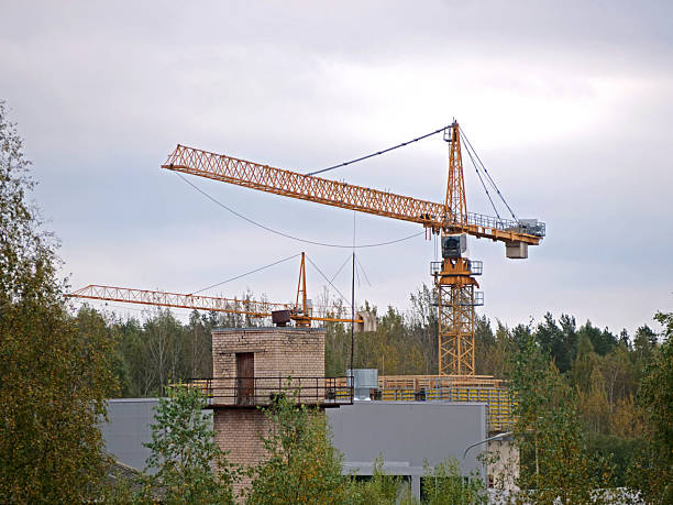 Industrial construction building crane against blue cloudy sky in background