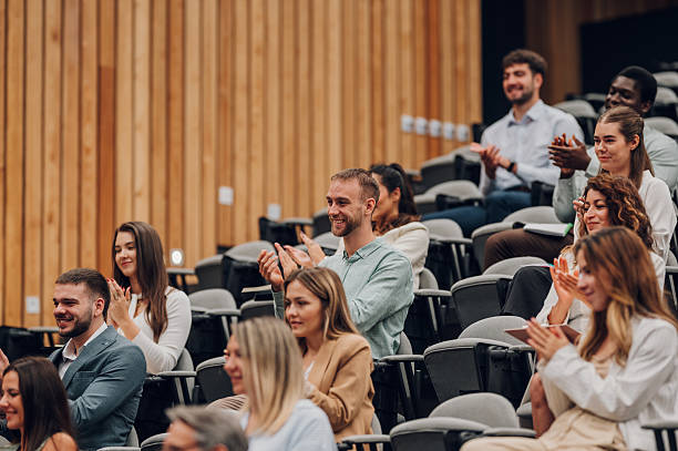 istock Audience members clapping during a business conference presentation 2239980071