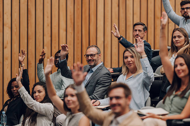 istock Diverse business professionals raising hands at conference 2239980122