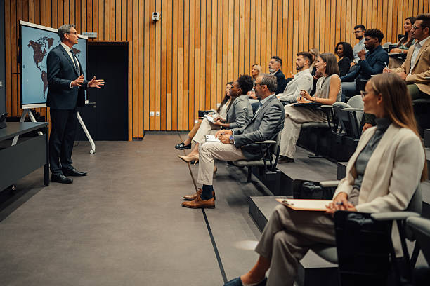 istock Business speaker presenting world map to diverse audience 2239980542