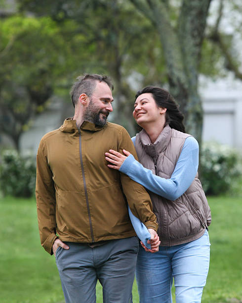 istock Happy middle-aged couple walking together outdoors on cloudy cold day 2239982197