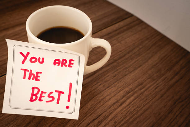 A positive message on a sticky note, on a cup of coffee. Creative background.