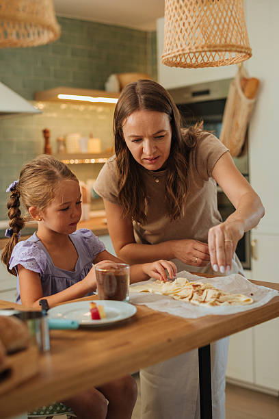 Mother and daughter preparing apple strudel in the kitchen