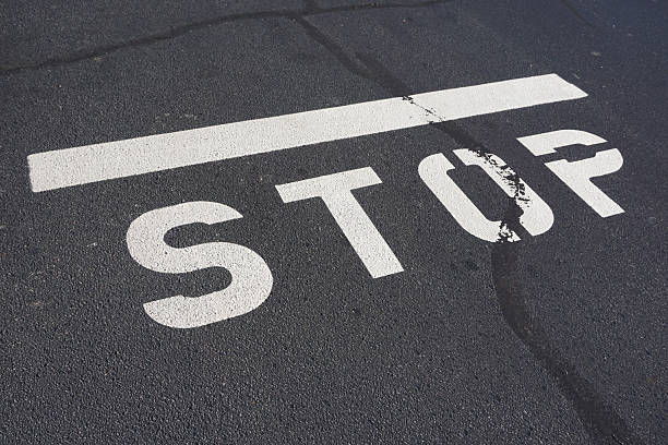 istock stop text sign painted on the asphalt road surface 2239990151
