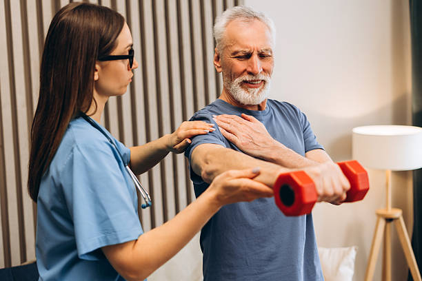 istock Senior man experiencing shoulder pain during physical therapy, mature patient doing exercises 2239990758