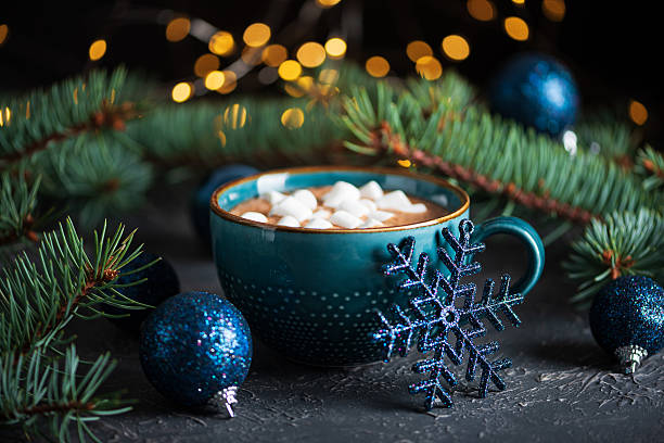 Hot Chocolate with Marshmallows in Teal Mug Surrounded by Christmas Decor