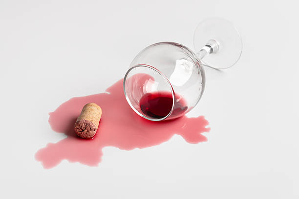istock Spilled red wine with glass and cork on white background 2239992903