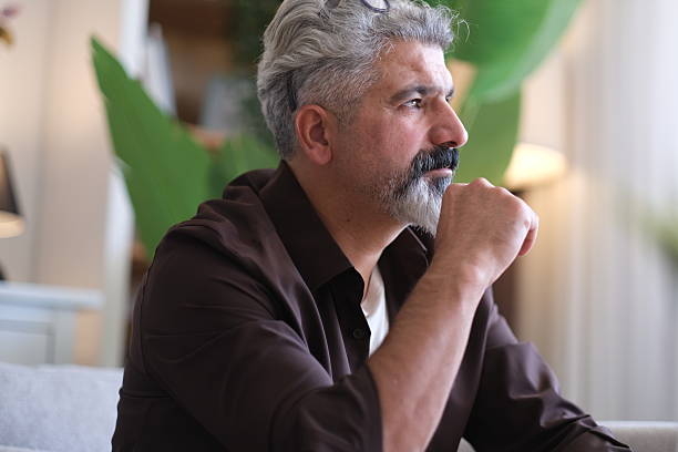 istock Man sitting alone at home looking sad and distraught 2239994825