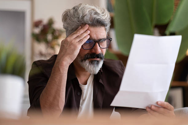 istock Upset frustrated mature man holding reading postal mail letter 2239994850