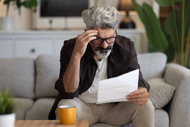 istock Upset frustrated mature man holding reading postal mail letter 2239995482