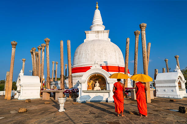 Sri Lankan buddhist monks walking inside an ancient temple near Anuradhapura, Sri Lanka
