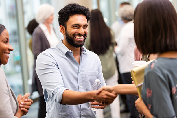 istock Diverse professionals networking and shaking hands in a positive indoor environment 2239995854