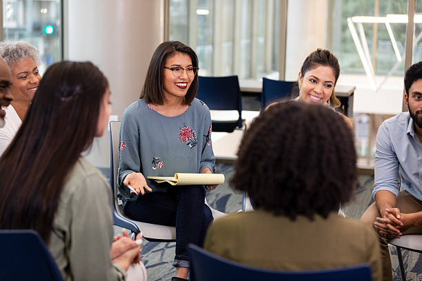 istock Diverse group of people engaged in a supportive discussion in an indoor setting. 2239995873