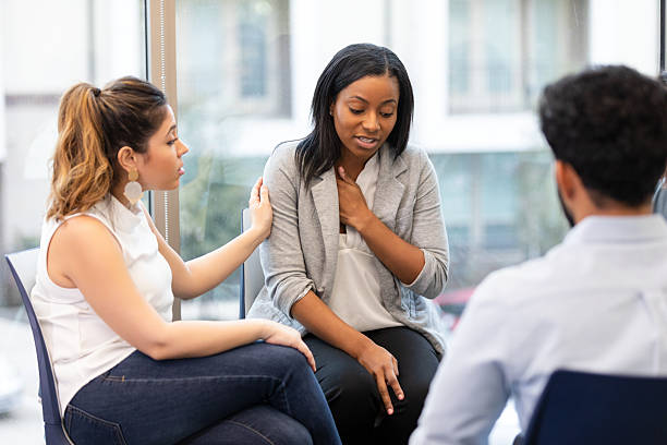 istock People in group therapy session offering support and empathy to a distressed individual. 2239995889