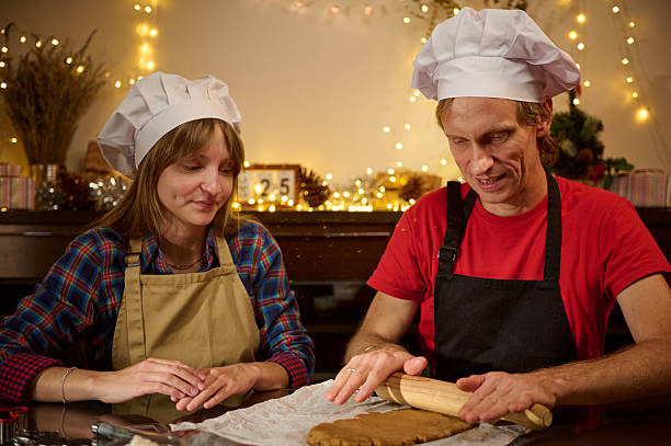 istock Cooking Duo: Chefs Rolling Dough in Festive Kitchen, Christmas Lights 2239995969